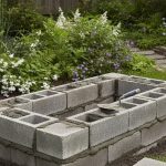 Construction d'une jardinière en parpaing dans un jardin avec lit de mortier.