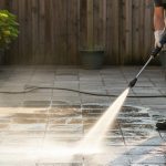 Nettoyage d'une terrasse avec un nettoyeur Kärcher et une lance rotative, montrant l'efficacité du jet d'eau.