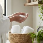 Femme utilisant des produits d'hygiène intime doux dans une salle de bain naturelle