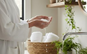 Femme utilisant des produits d'hygiène intime doux dans une salle de bain naturelle